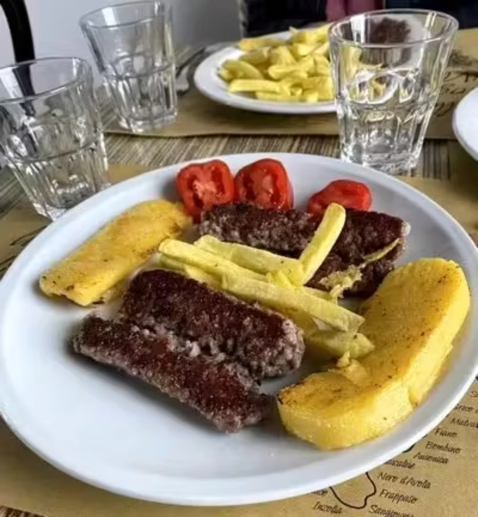 Piatto con salsiccia e polenta o patatine